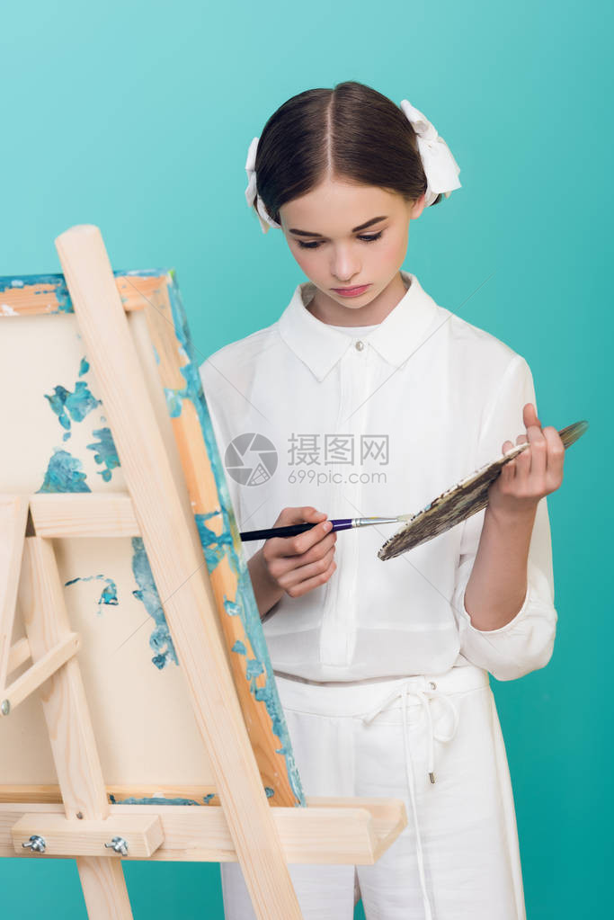 美貌的青少年艺术家绘画用刷子和调色板图片