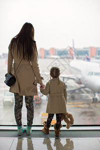 妈和小女儿在机场航站楼望着窗外图片