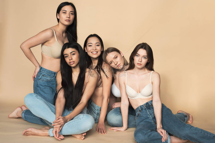 5名身着蓝牛仔裤和胸围的美丽多文化青年妇女图片