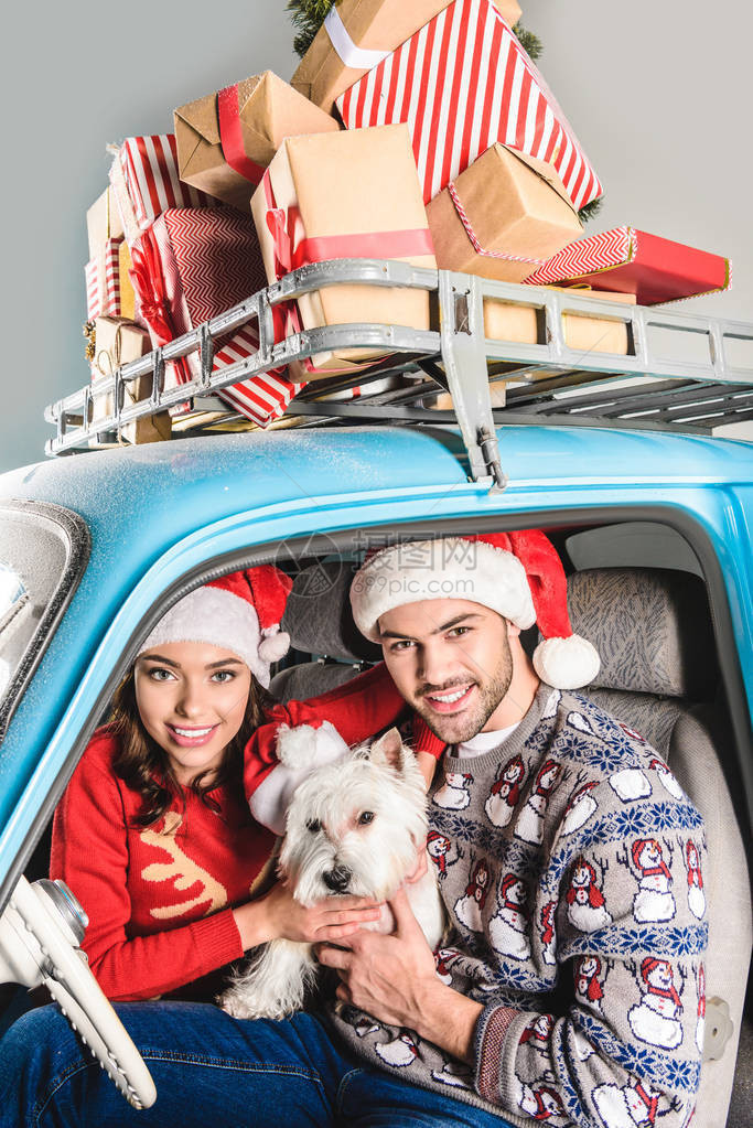 带着圣诞礼物的蓝色轿车坐着狗的家庭幸图片