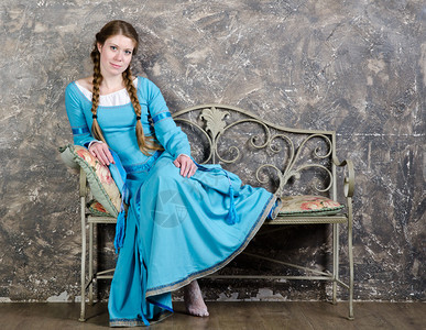 穿着历史中世纪蓝色礼服的嬉戏女青年图片
