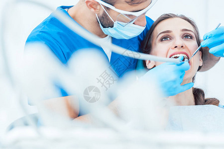 一名经验丰富专心致志的牙医在现代牙科办公室接受无痛口服治疗时图片