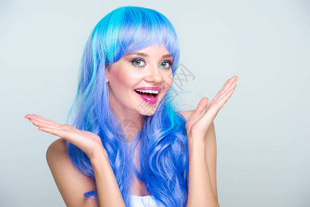 带着明亮蓝头发的兴奋的年轻女子在图片