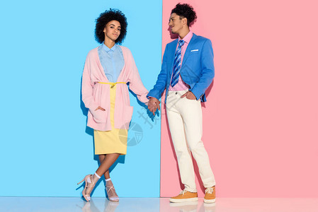 年轻的非洲裔美国人微笑着的女孩和男人在粉色和蓝色图片