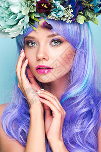 穿着卷蓝色头发和花圈的漂亮年轻女子的图片