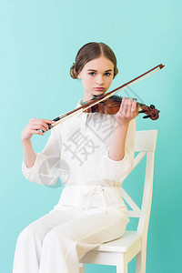 少女拉小提琴坐在椅子上孤立图片