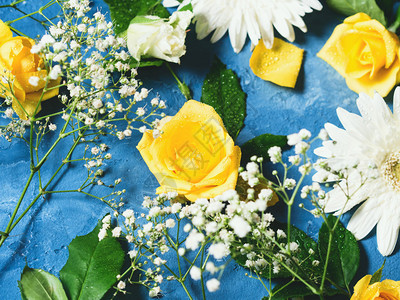 蓝色背景下玫瑰和格柏的花卉组合图片