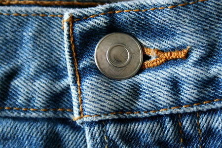 蓝色牛仔裤按钮的特写图片