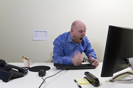 愤怒的办公室工人商人撞到了他的电脑图片