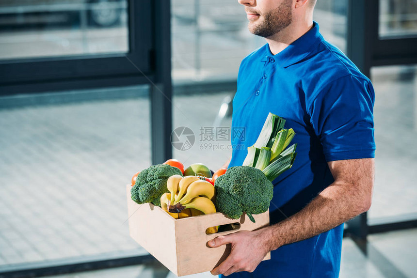 快递拿着新鲜水果和蔬菜的盒子图片