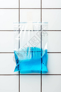 泥砖墙上挂着蓝色水的塑料袋图片