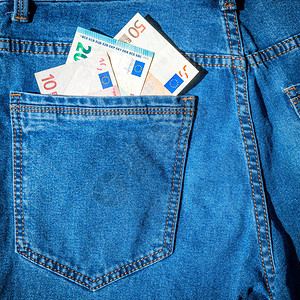 蓝色牛仔裤口袋里的欧元现金图片