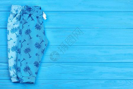 蓝色木质背景上的现代口袋男婴和女婴棉裤图片