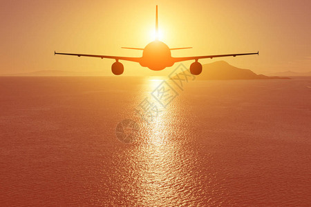 飞机在日落时飞越海图片