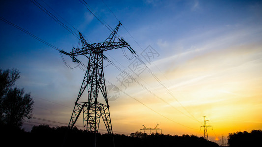 夕阳背景下的高压输电塔剪影图片
