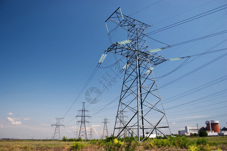 明蓝天下电线和核电站的电力背景图片