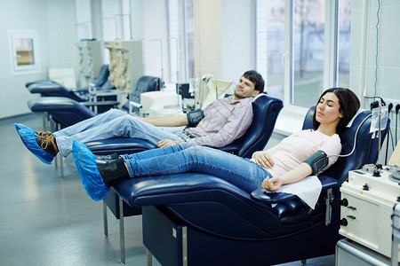 男孩和女孩躺在扶手椅上准备输血图片