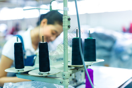 印度尼西亚工厂的亚洲女裁缝或工人用工业缝纫机缝制高清图片