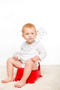 穿着体服的可爱婴儿坐在白边被图片