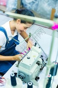 棉卷印度尼西亚工厂的亚洲女裁缝或工人用工业缝纫机缝制背景
