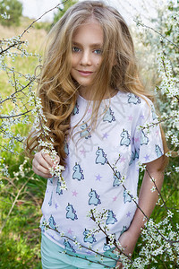 夏季童装详情页金发长的可爱小女孩站在花环的草地上背景