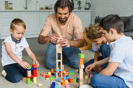快乐的父亲和孩子玩木砖块一起在家图片