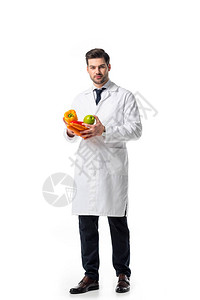 白大衣有营养学家新鲜蔬菜和苹果在白图片