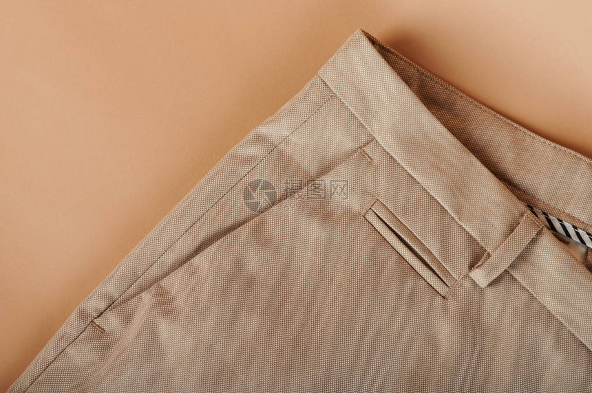 米色背景上经典裤袋的特写图片