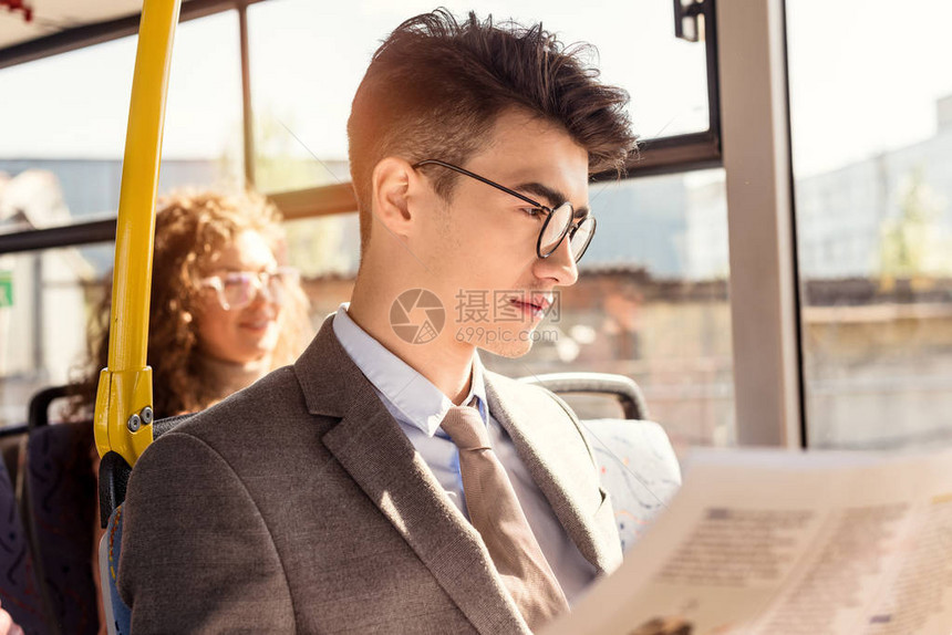 公共交通中男阅读报纸有选择重心在图片