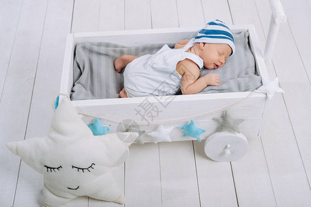 睡在木制婴儿床的可爱新生儿图片