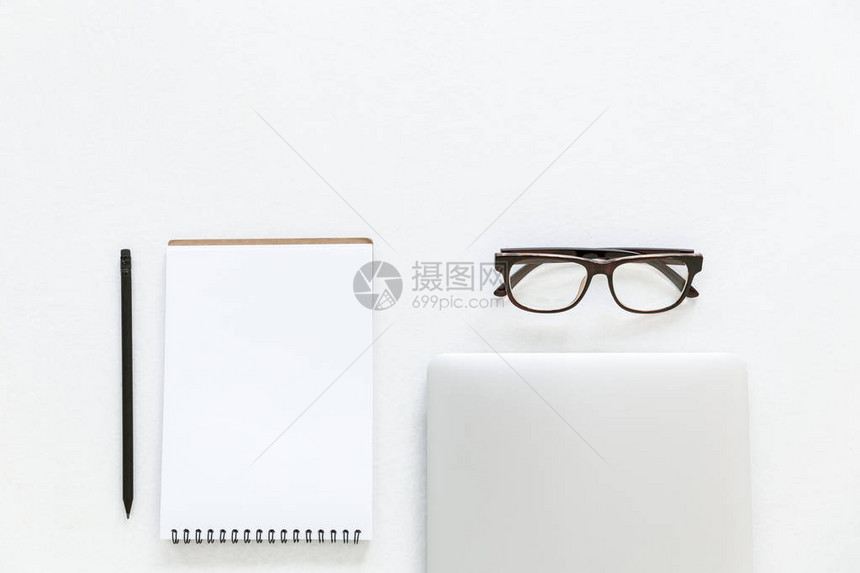 用笔记本笔记板和眼镜以白色隔开的图片