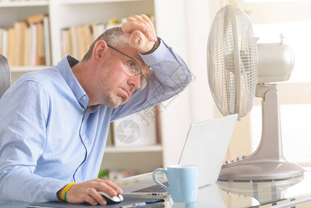 男人在办公室工作时受炎热试图被图片