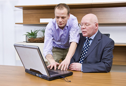 计算机技术人员正在向公司董事展示如何操图片