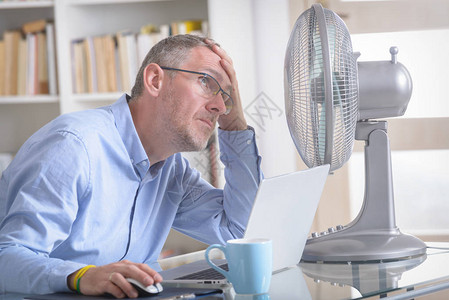 男人在办公室工作时受炎热试图被图片
