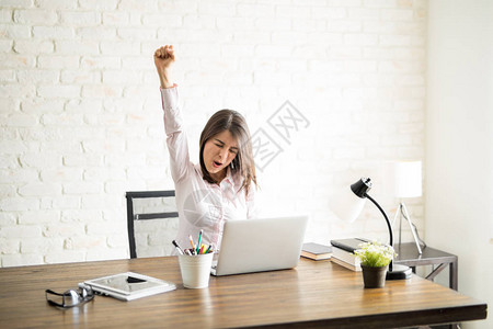 女企业家尖叫着幸福举起她的手臂作图片