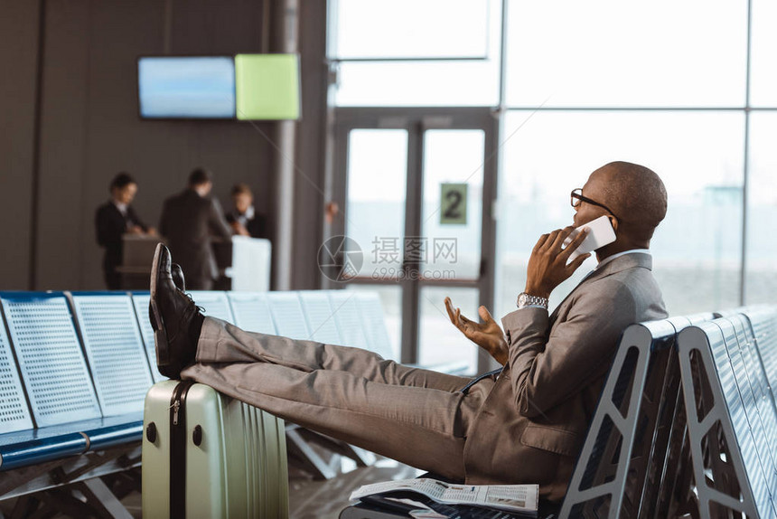 商人在机场大厅等候飞行时通过电话交谈在机场图片