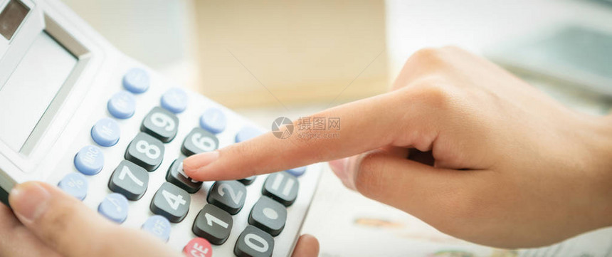 女会计师或银行工人在办公室使用计算器进行商业盈利和亏损账户的计算图片