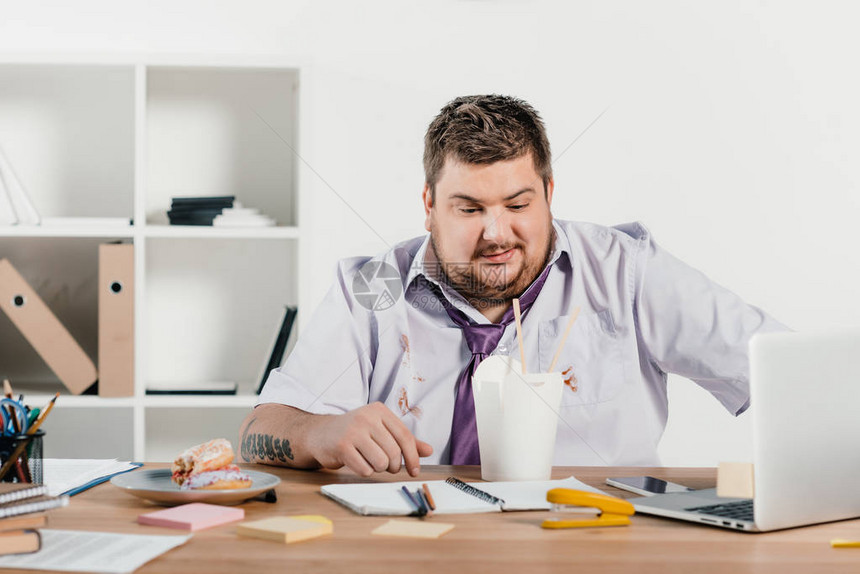 超重量体重的商人在办公室工作图片