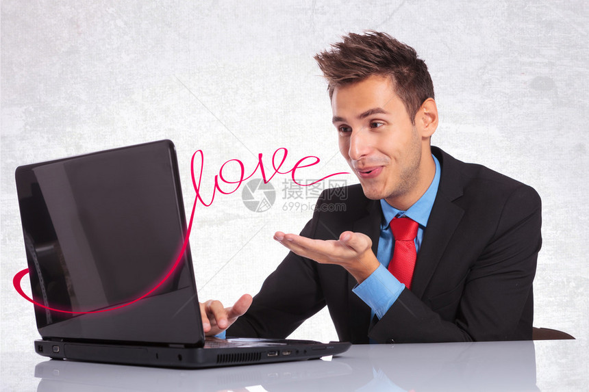 身穿西装的年轻人把他的爱传达给在电脑聊天中图片