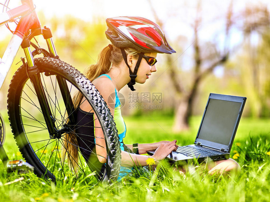夏天公园里的女人旅行自车骑自行车的女孩在笔记本电脑上观看女孩在运动训练后数脉搏图片