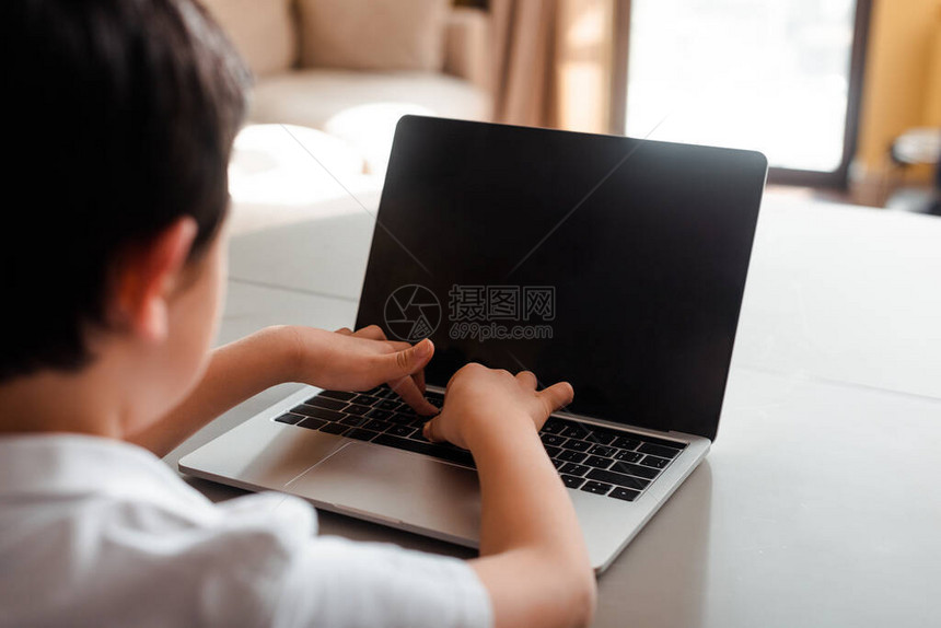 男孩在自孤立时在家里用空白屏幕打上笔记本电脑的网图片