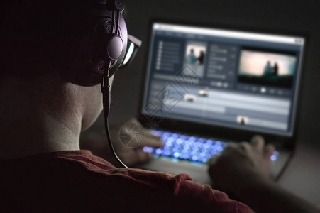 LED背景视频素材使用笔记本电脑进行视频编辑专业编辑添加特殊效果或颜色分级素材年轻人使用计算机软件和背景