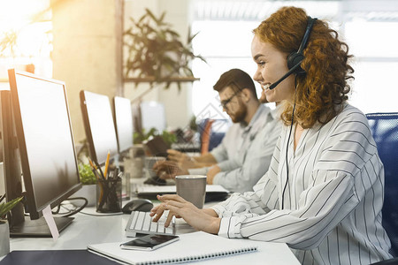 客户支持呼叫中心积极的女运营商通过电话咨询图片