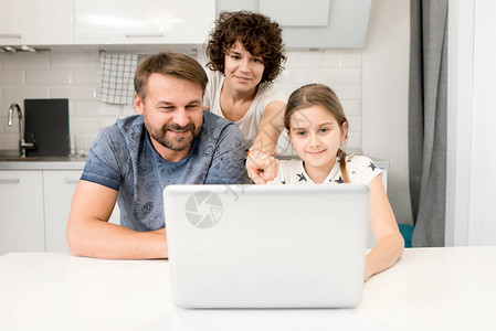 幸福的年轻家庭透过笔记本电脑观看视频图片