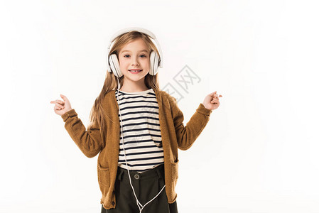 微笑的小孩听音乐用耳机在白色上孤立的图片