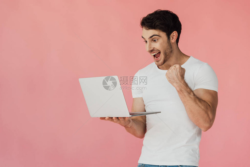 穿白色T恤白T恤用笔记本电脑显示在粉红色上孤立的图片