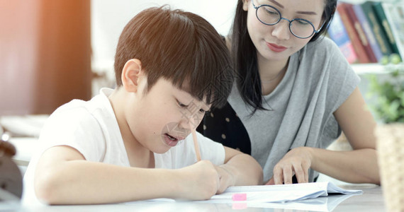 有儿子在做功课的亚洲母亲妈教儿子如何图片