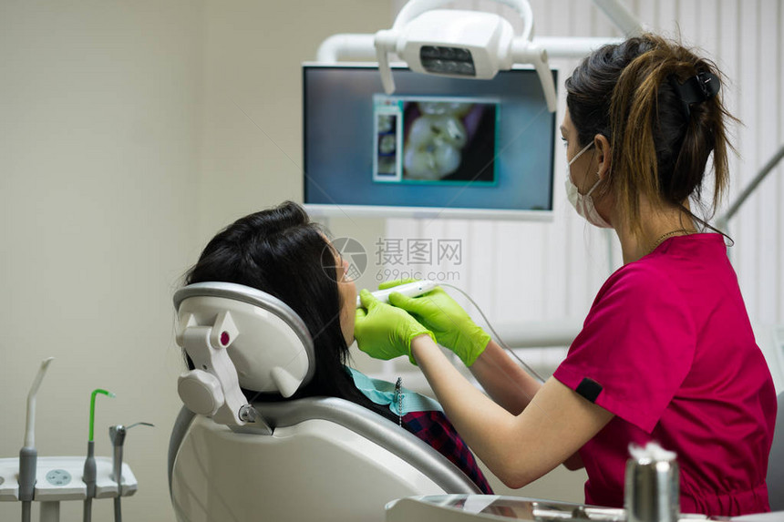牙医在牙科诊所用远程摄像头检查女人的牙齿牙齿的图片在屏幕图片