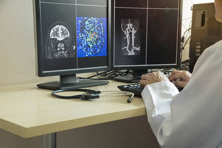 医生使用键盘在医疗办公室的计算机监视器上查看图片