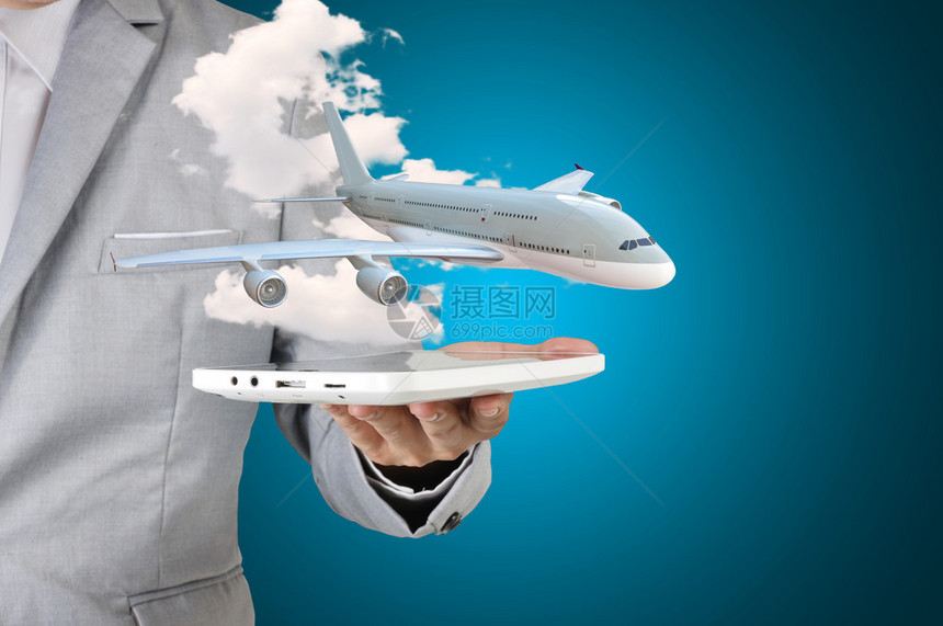 拥有平板电脑的商人将手中的飞机作为运输或旅行概图片